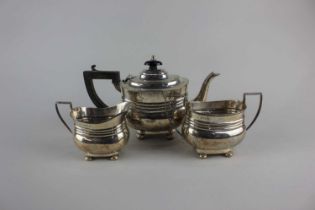 An Edward VII silver three-piece bachelor tea set oval form with reeded girdle and button feet,