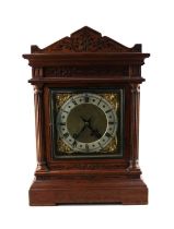 A Winterhalder & Hofmeier carved oak mantle clock, the brass and silvered dial with Roman