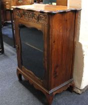 A 20th century pier cabinet, with serpentine top above a carved drawer and glazed panel door