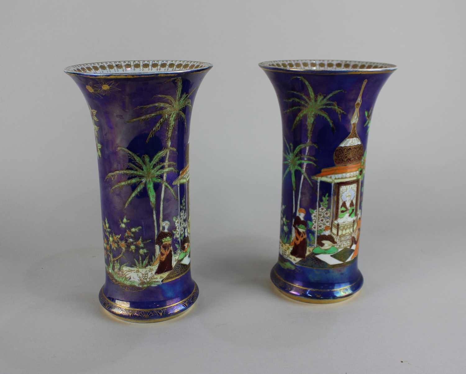 A pair of Carlton Ware Persian pattern cylindrical vases decorated with a temple within gilded