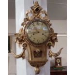 A 20th century giltwood wall clock, with pierced ribbon surmount and floral decoration 53cm, with