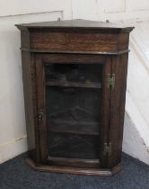 A George III style oak hanging corner cupboard with glazed door enclosing two shelves, 47cm