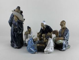 Five Chinese mudman type figures in various poses to include a figure playing a flute 11.5cm, and