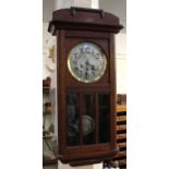 An early 20th century oak cased wall clock 81cm high, with pendulum and key