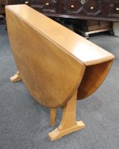 An Ercol oval drop leaf dining table on shaped end supports with gate-leg action 127cm