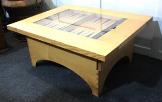 A modern ash coffee / games table, the rectangular top inset with glass panel enclosing a stained