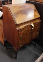 A 20th century walnut serpentine fronted bureau, with fall above frieze drawer and two further