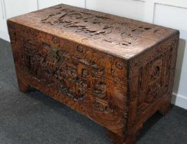 A Chinese camphor wood trunk carved with figural scenes of warriors on horseback 100cm