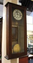 A Vienna style oak cased wall clock, 78cm high, with pendulum, weight and key (glass a/f)