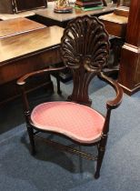 A 19th century mahogany elbow chair, with pierced shell shaped back and kidney shaped seat on turned