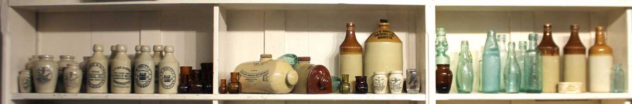 A collection of stoneware and glass drinking bottles, jars and foot warmers, to include F Chitty