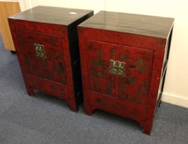 A pair of Chinese black and red lacquered cabinets decorated in gilt with figures in a garden (a/f),