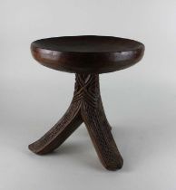 A West African carved three legged stool, possibly from Kano, Nigeria