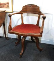 An early 20th century oak office chair on swivel base with castors