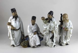 Four Chinese white glazed mudman type figures to include Shoulao 24cm high