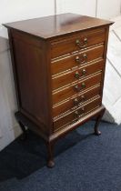 A mahogany music cabinet six drawers with fold down fronts and brass drop handles, on cabriole legs,