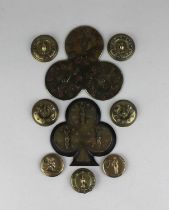 A collection of brass whist and bezique markers, some with hand motifs