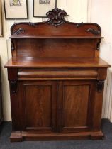 A Victorian mahogany chiffonier with scrolling foliate raised back and single curved shelf, over