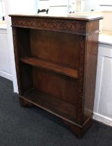 A carved oak bookcase with single adjustable shelf on bracket feet, 92cm