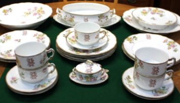 A Limoges porcelain part dinner service monogrammed with the initials 'BH' amongst floral