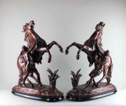 After Guillaume Coustou (1677-1746), a pair of brown painted metal models of Marly horses, 66cm high