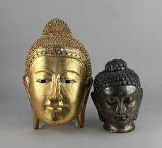 A carved giltwood Buddha head mounted as a wall plaque, with coloured glass decoration 28cm high,