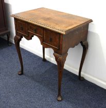 An early 20th century walnut side table with quarter veneered crossbanded top, three drawers and