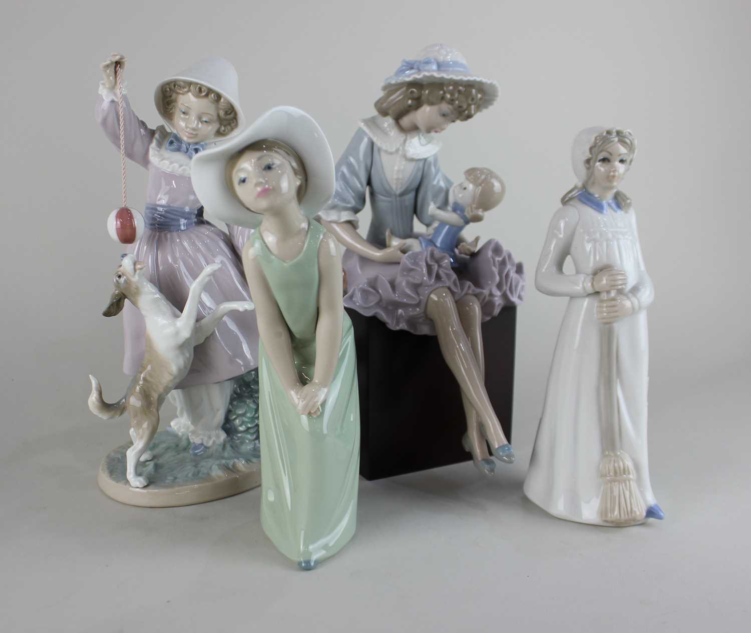 A group of Lladro of four figurines comprising of Teasing the Dog, Debbie and her Doll along with