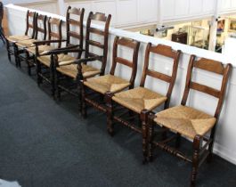 A harlequin set of eight oak and rush seat dining chairs to include two ladderback carvers on turned