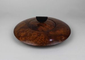 An Art Deco style circular burrwood box disc shape with lid and half moon handle, 25cm