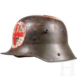 Stahlhelm M 16 eines Sanitäters mit Gefechtsschaden