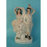 A good Staffordshire group depicting a couple he with a mask and she a veil, well gilded,