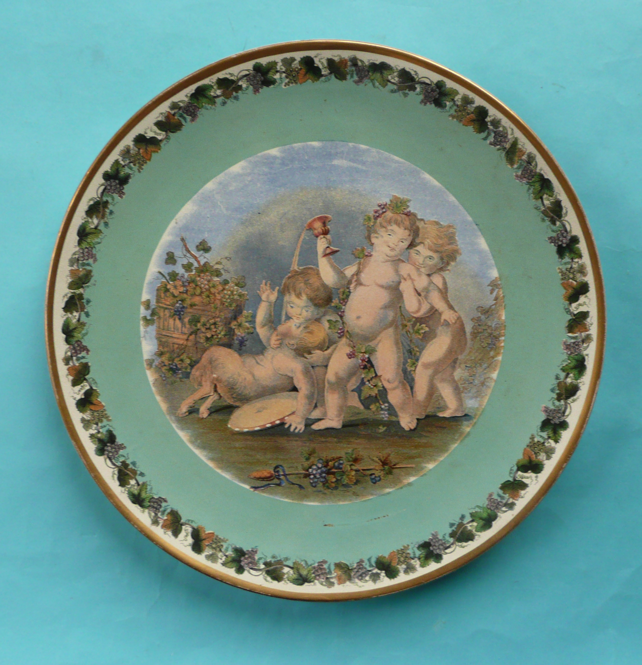 A large circular plate by Doulton Burslem: Bacchanalians at Play, vine leaf and grape border