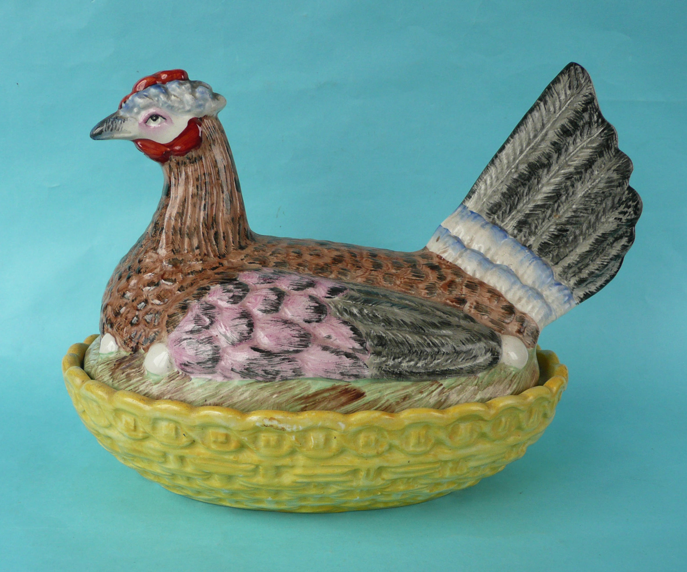 A good and colourful Staffordshire pottery tureen and cover modelled as a hen on a basket