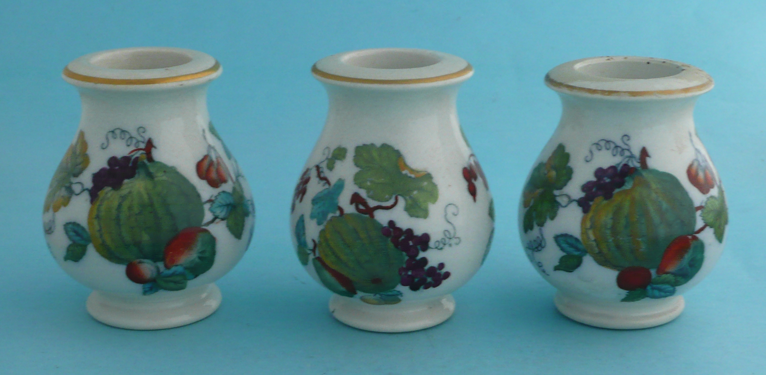 Three small baluster shaped jars with fruits and foliage