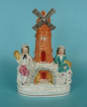 A good and colourful Staffordshire pottery group of a windmill flanked by figures holding