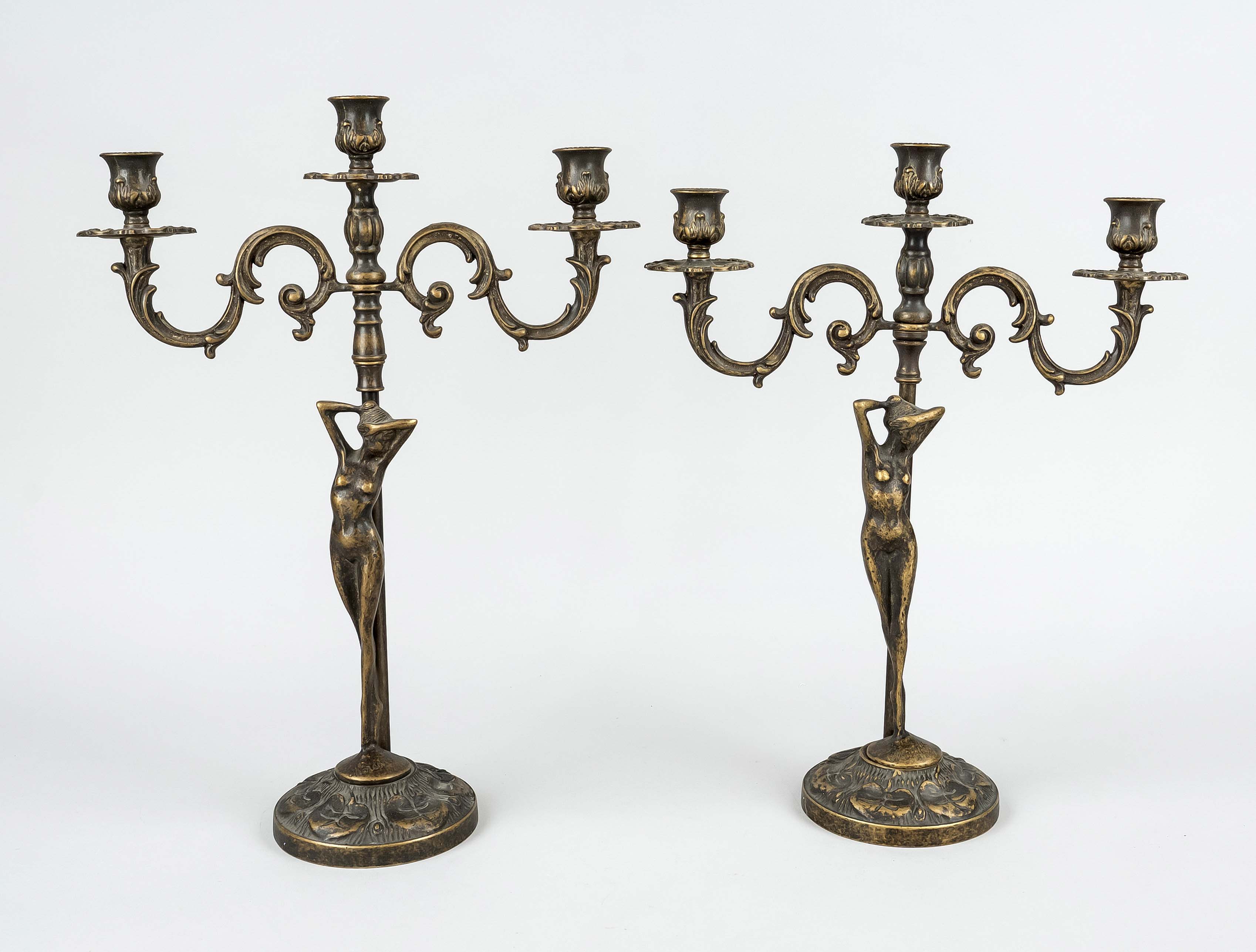 Pair of figural candlesticks, 20th c., brass patinated. Round base with water lily relief, shaft