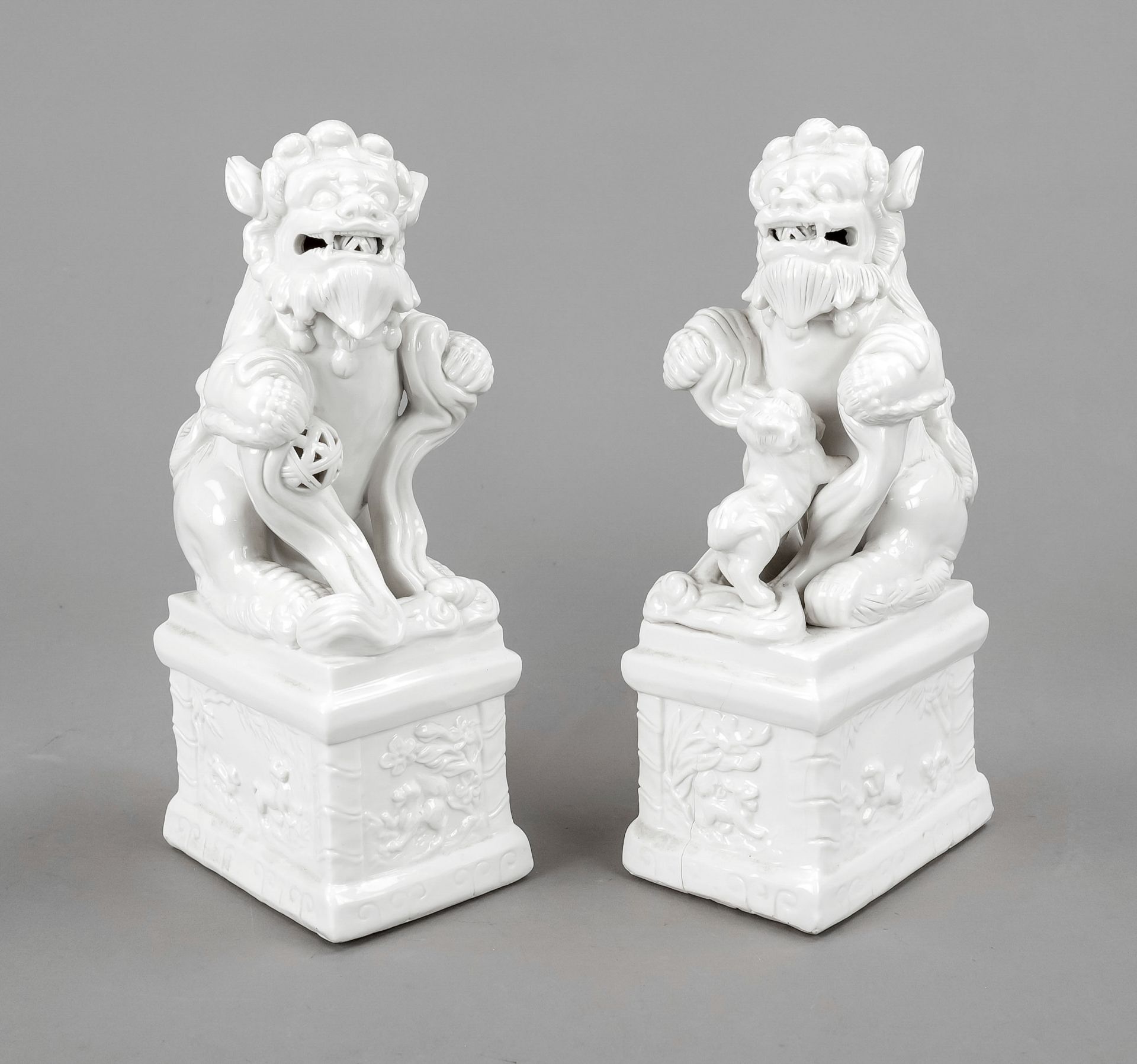 Pair of guardian lions Blanc de Chine, China, 19th/20th c., dehua porcelain of a male lion with a