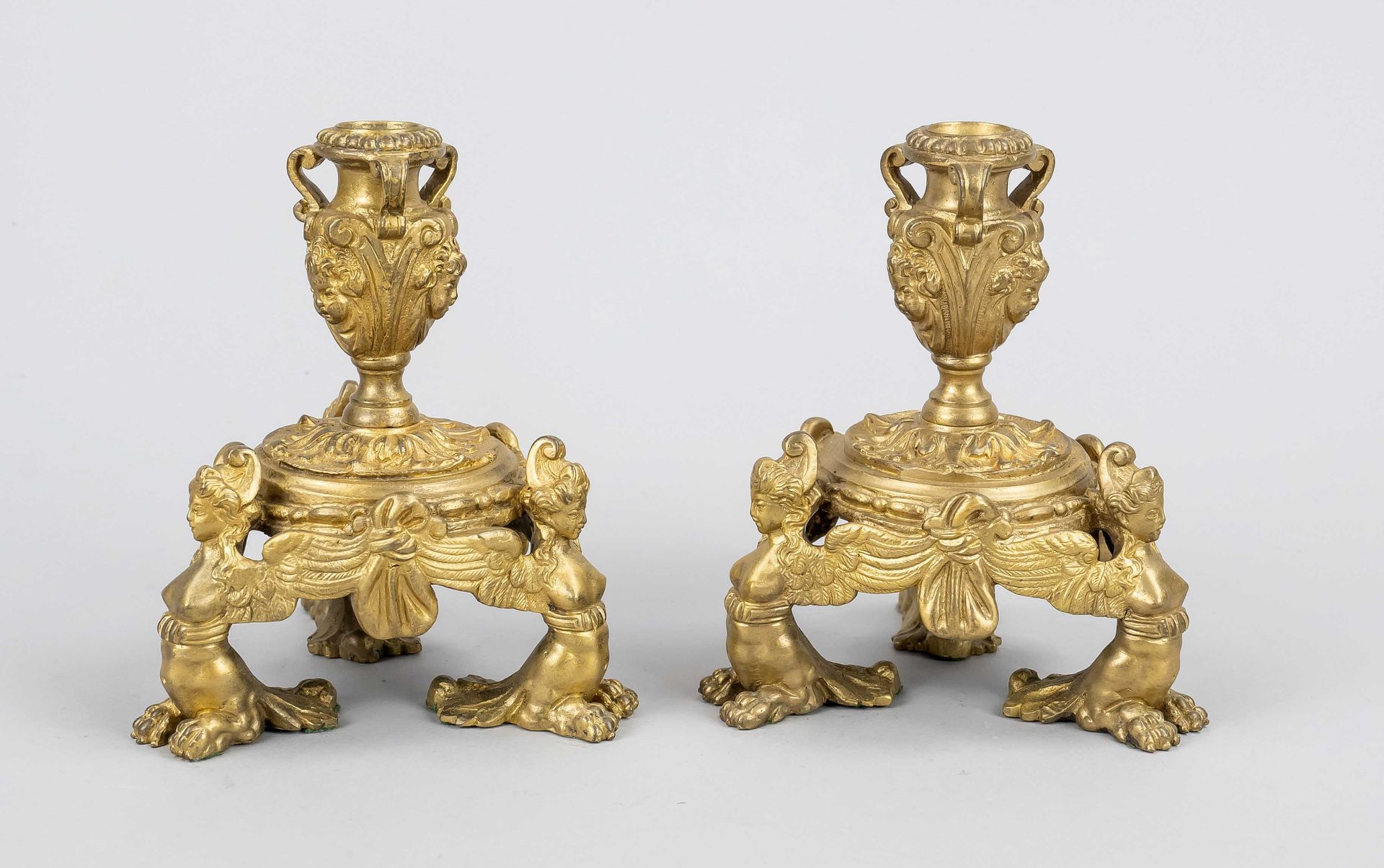Pair of candlesticks, 19th c., bronze, gilded. Tripod stand with sphinx-like figures, vase spouts