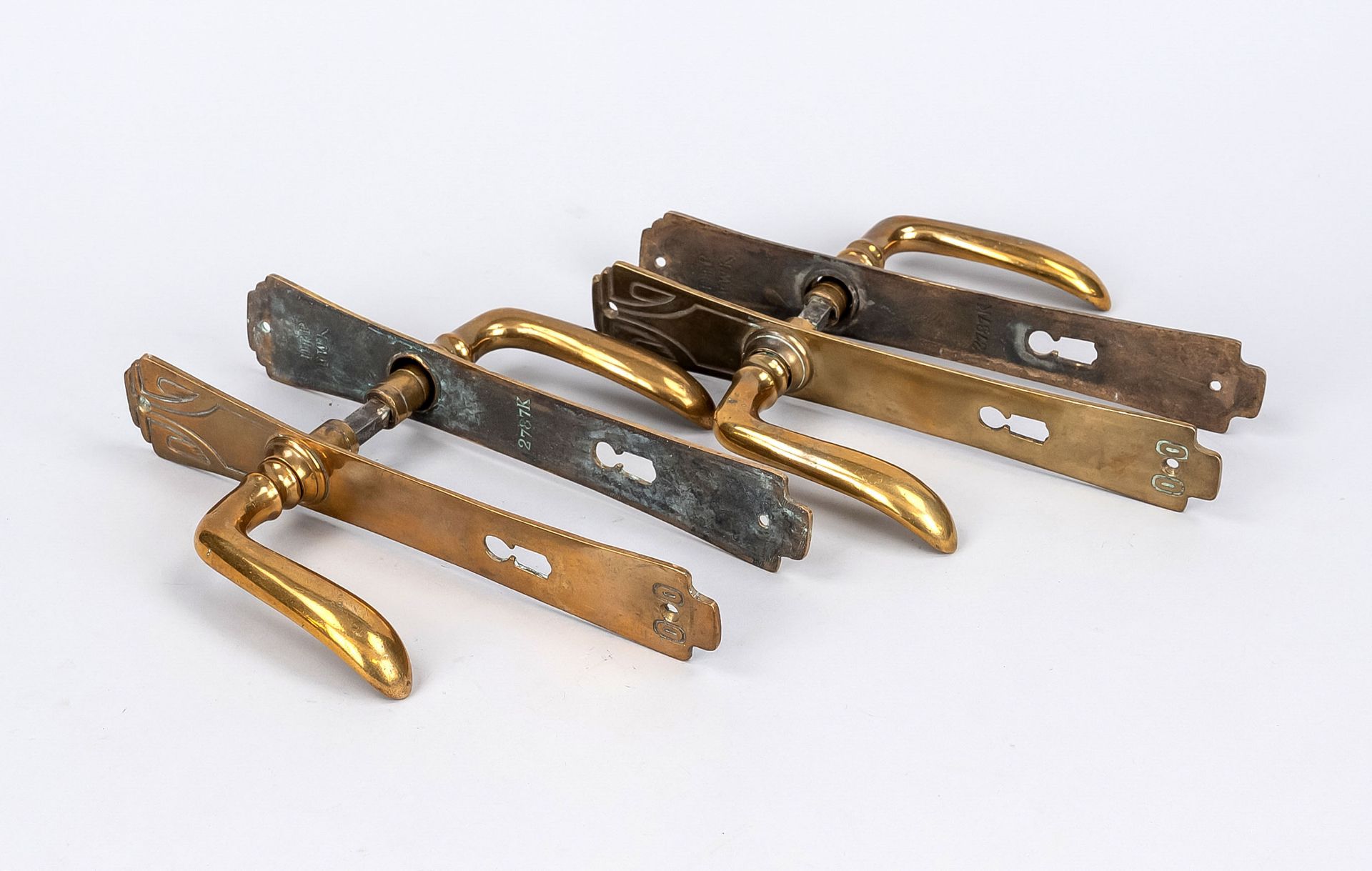 Pair of Art Nouveau lever handles, around 1900, brass. Fitted curved fascia with vegetal ornament,