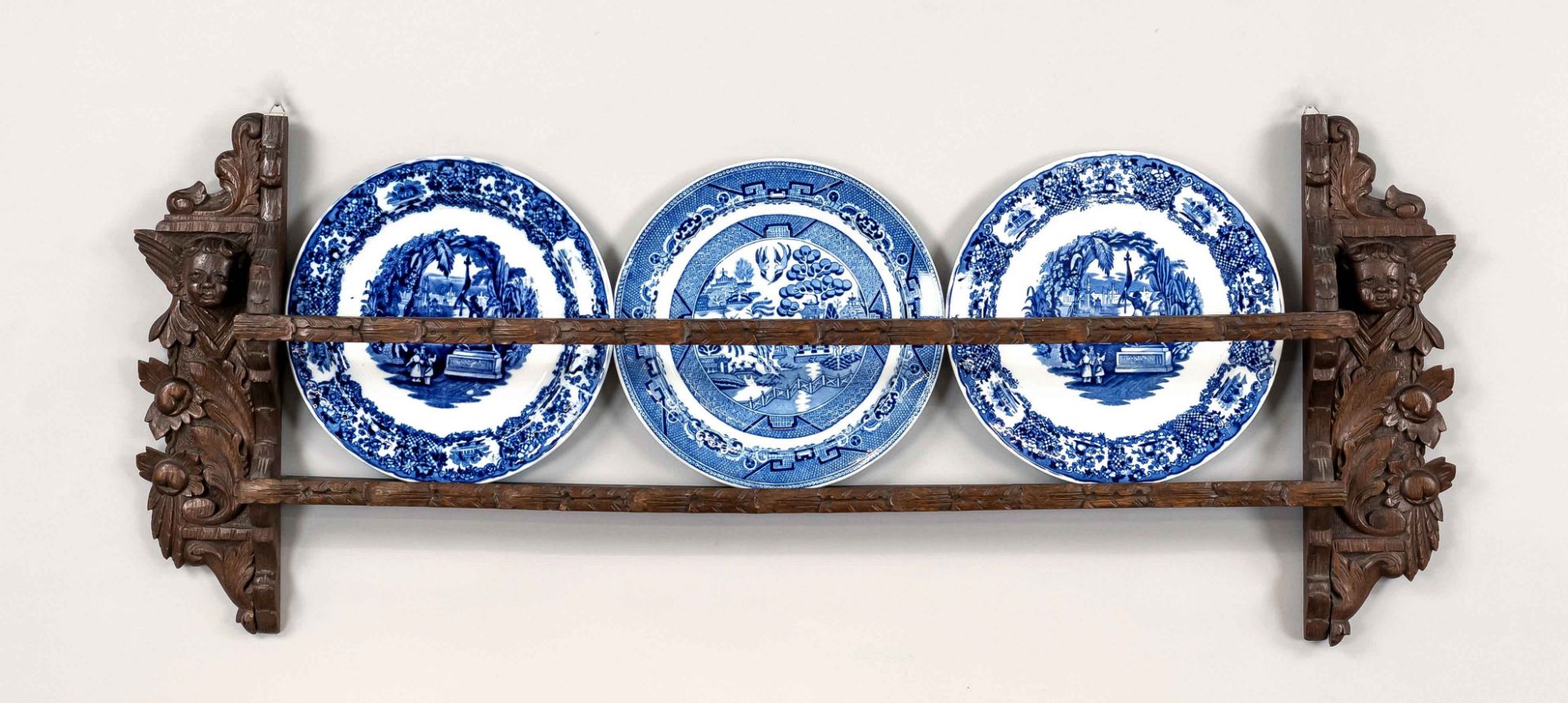 Plate shelf, Holland, 19th/20th c., oak shelf with carved cheeks with putti, in addition 3 blue-