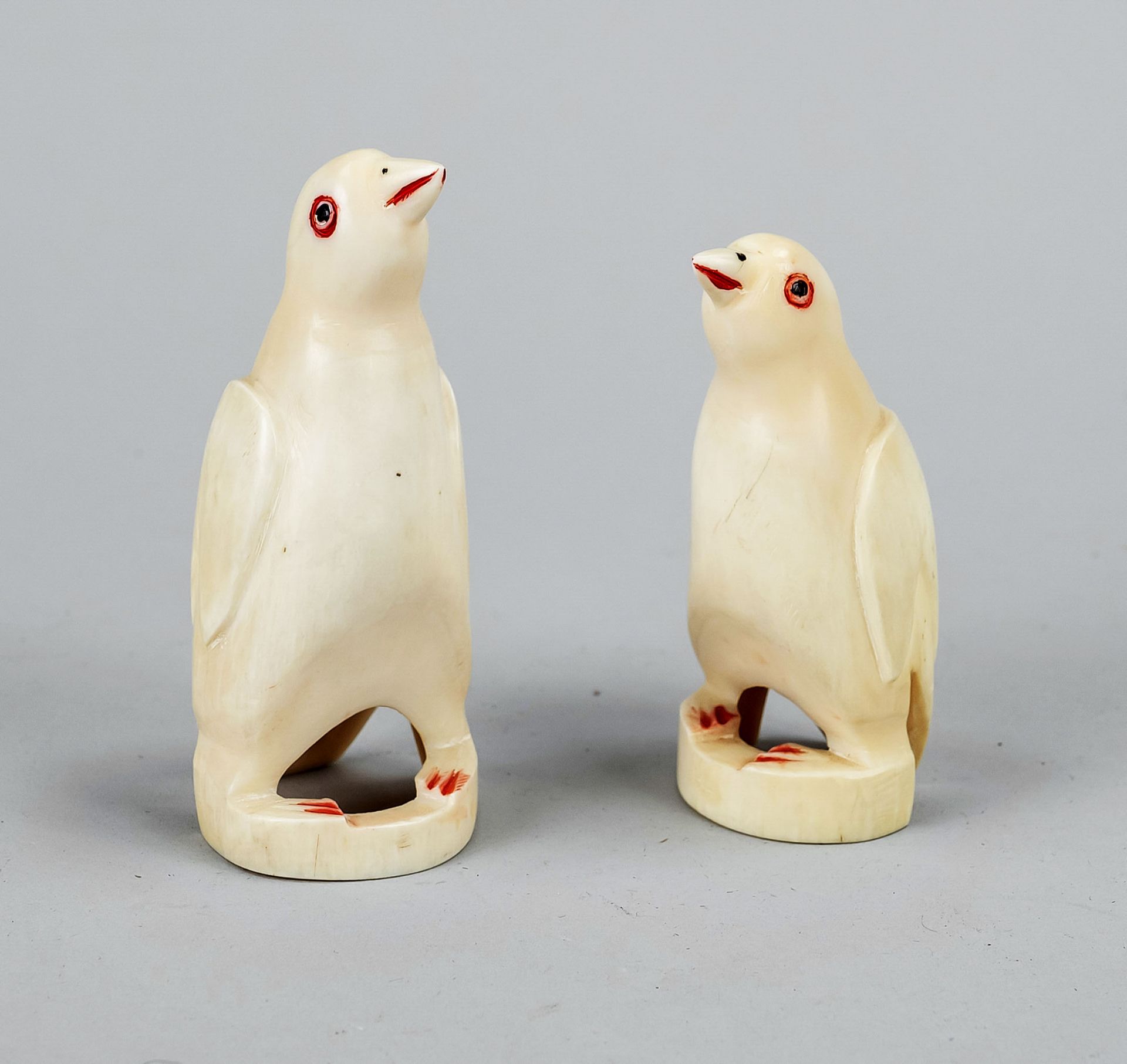 Pair of figurally carved walrus teeth, mid 20th c., partially color painted penguins, h. 8 & 10 cm