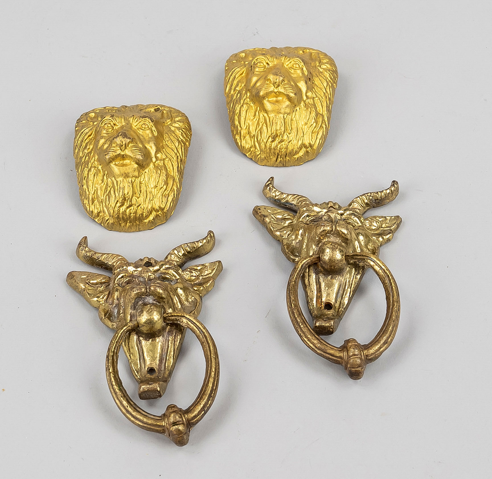 2 pairs of fittings, late 19th c., brass with residual gilding. 1 x lion mascarons, h. 7 cm. 1 x