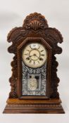 AN OAK CASED ANSONIA GINGERBREAD CLOCK.