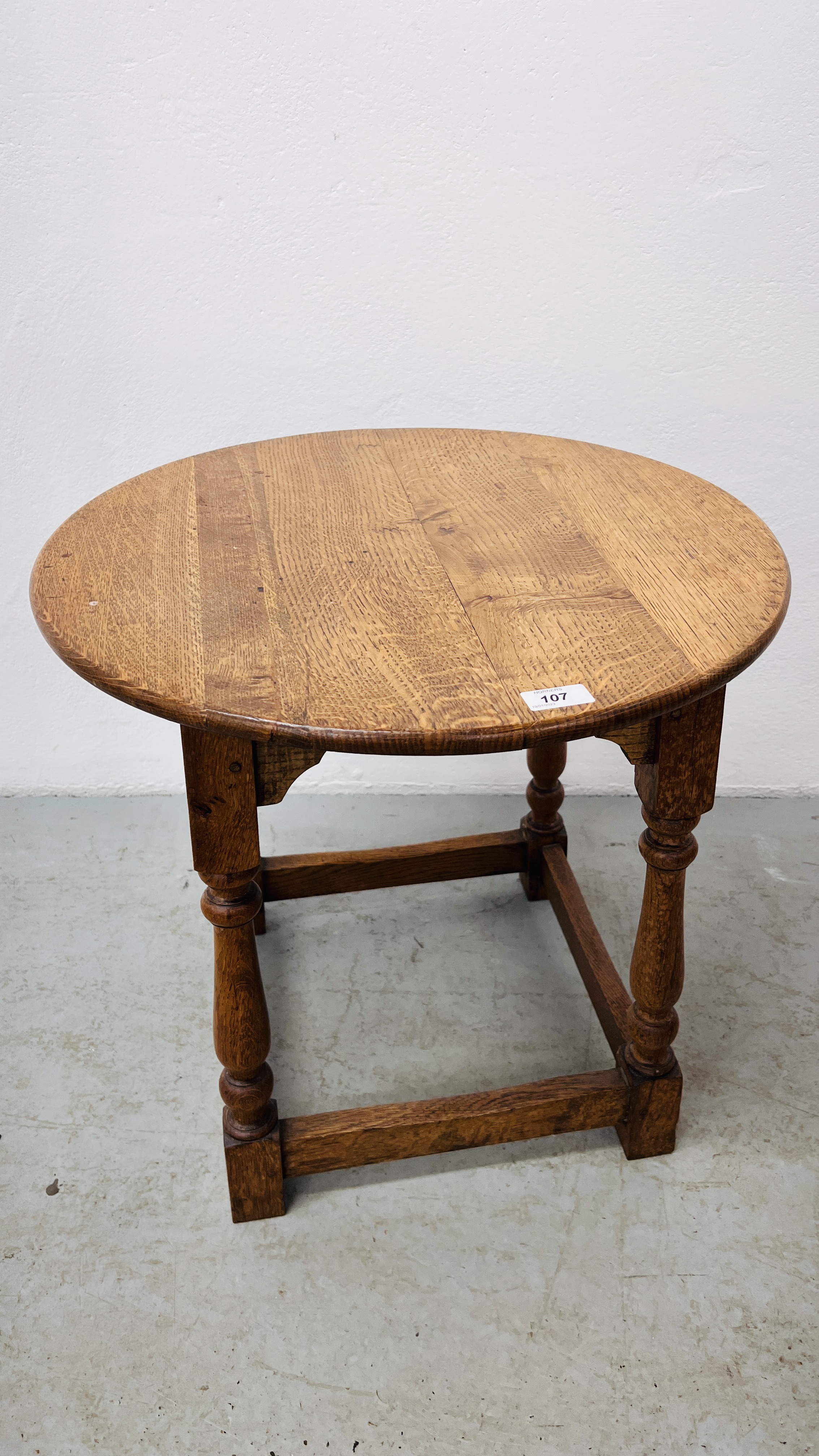 AN OAK CIRCULAR OCCASIONAL TABLE ON TURNED SUPPORTS HEIGHT 51CM. DIA. 54CM.