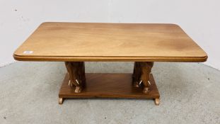 A SOLID MAHOGANY COFFEE TABLE, THE TOP SUPPORTED BY TWO CARVED ELEPHANTS 90 X 45CM.