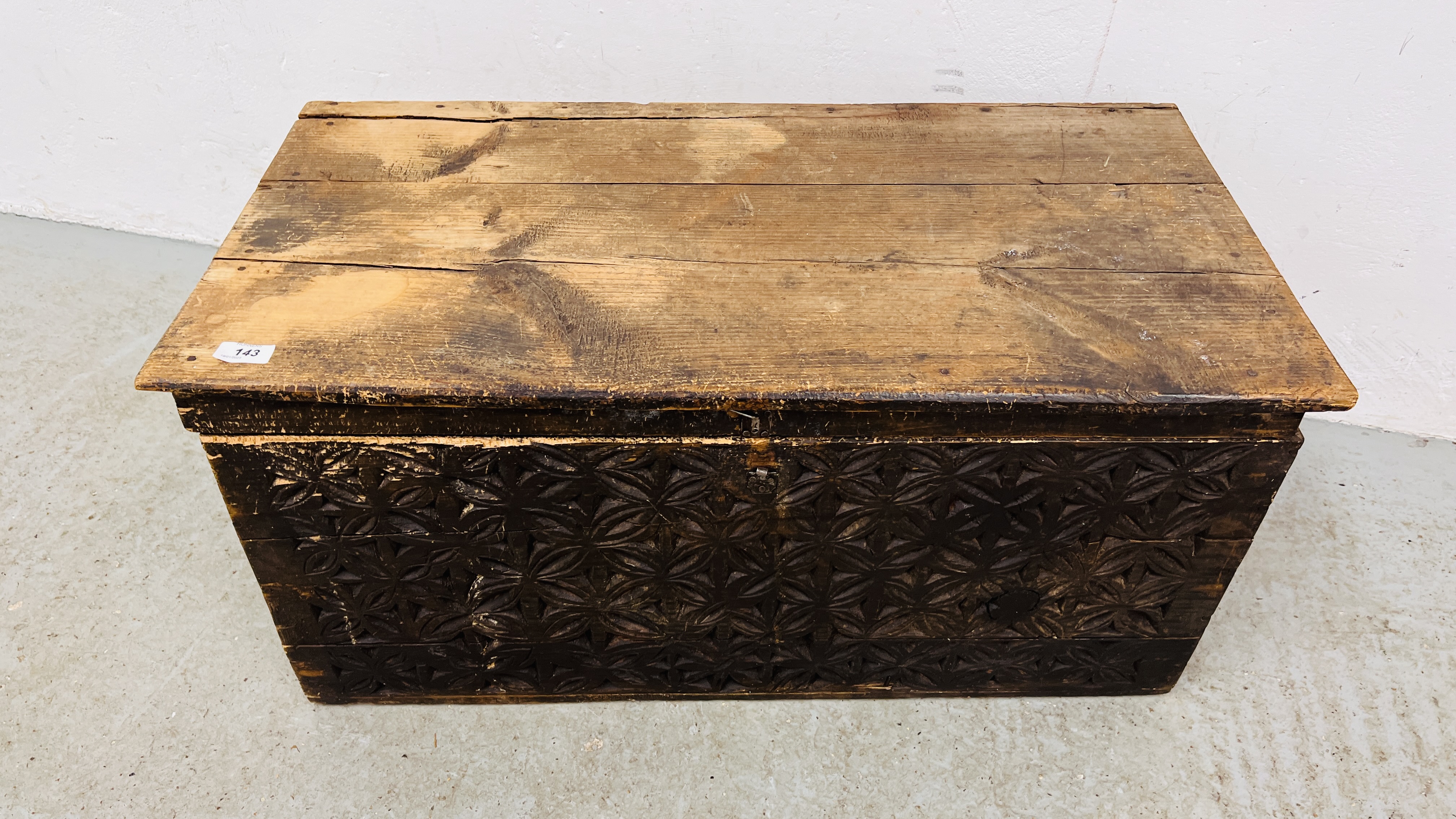 AN ANTIQUE PINE BLANKET CHEST WITH HAND CARVED FRONT PANEL WIDTH 85CM. DEPTH 43CM. HEIGHT 42CM.