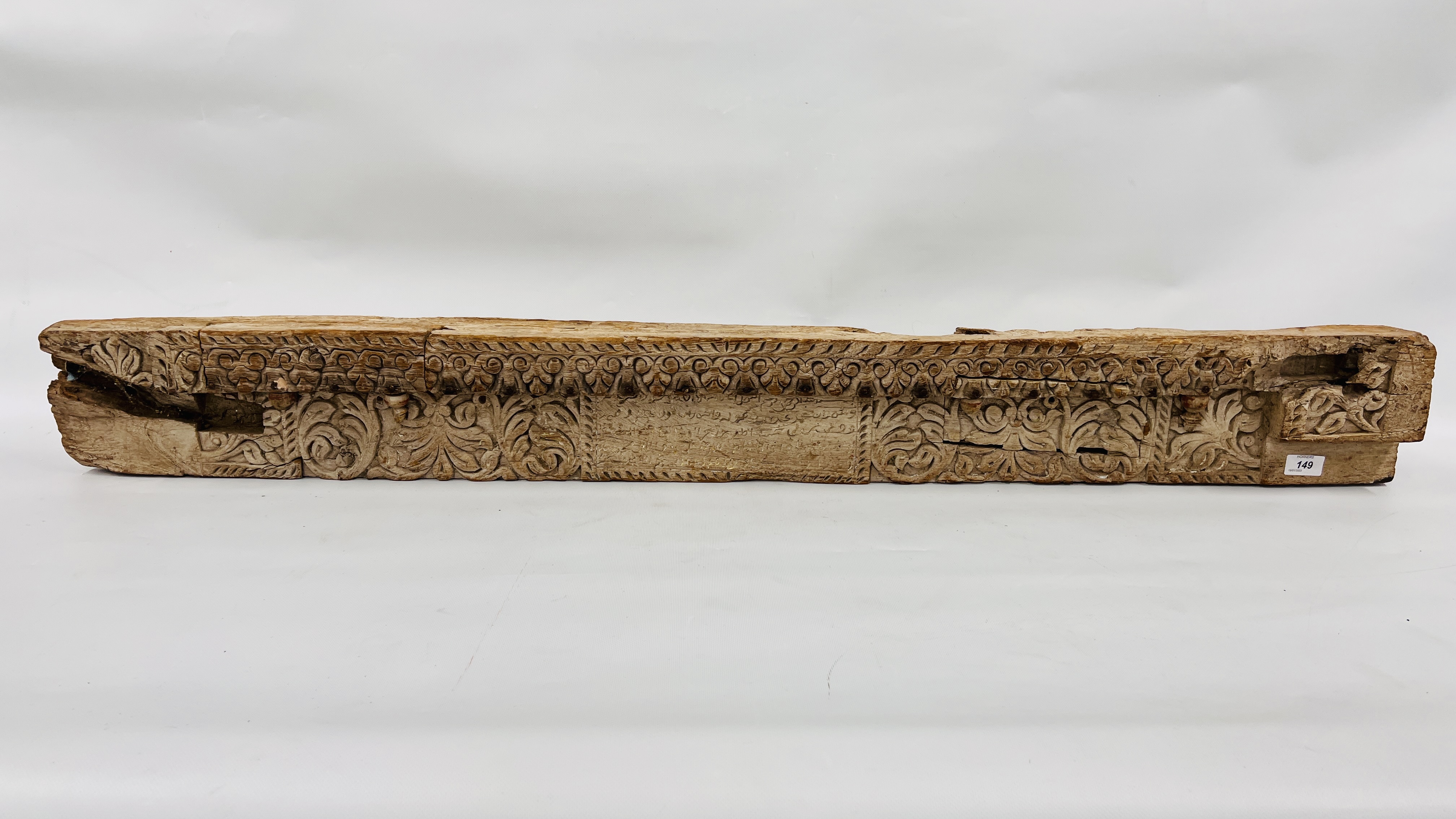 AN ANTIQUE HEAVILY CARVED HARDWOOD TIMBER BEAM WITH ISLAMIC RELIGIOUS INSCRIPTION LENGTH `34CM.