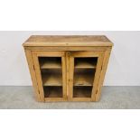 A VINTAGE WAXED PINE TWO DOOR GLAZED CABINET WIDTH 89CM. DEPTH 32CM. HEIGHT 86CM.