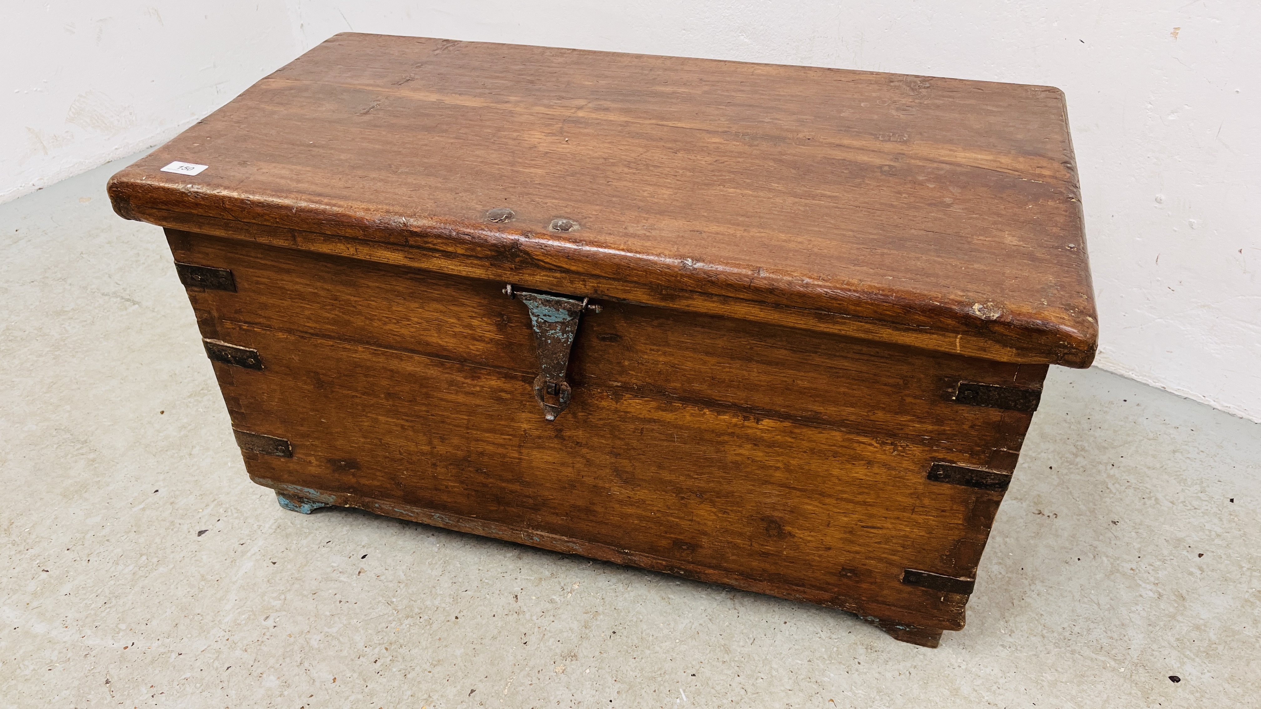 AN ANTIQUE HARDWOOD METAL BOUND TRUNK WIDTH 86CM. DEPTH 64CM. HEIGHT 45CM.